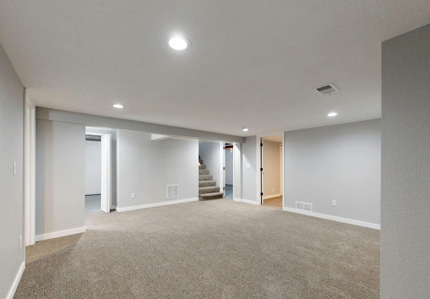 Finished basement family room with recessed lighting, carpet and painted walls