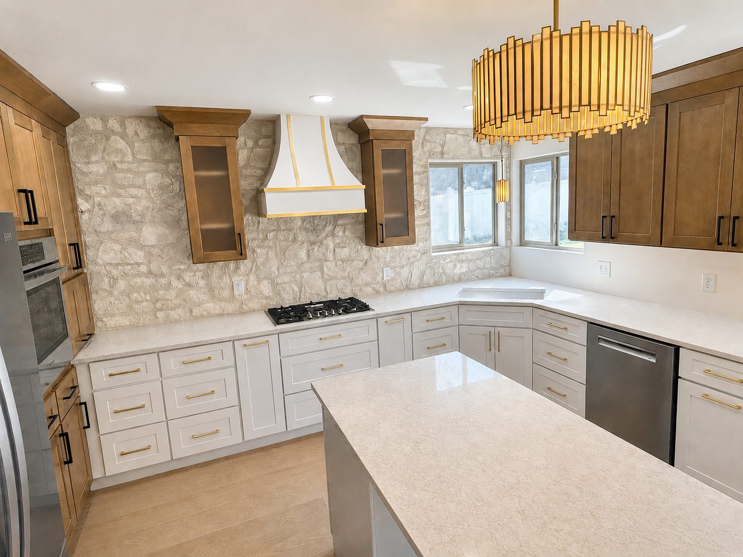 Remodeled kitchen with stone backsplash, custom white range hood and quartz island