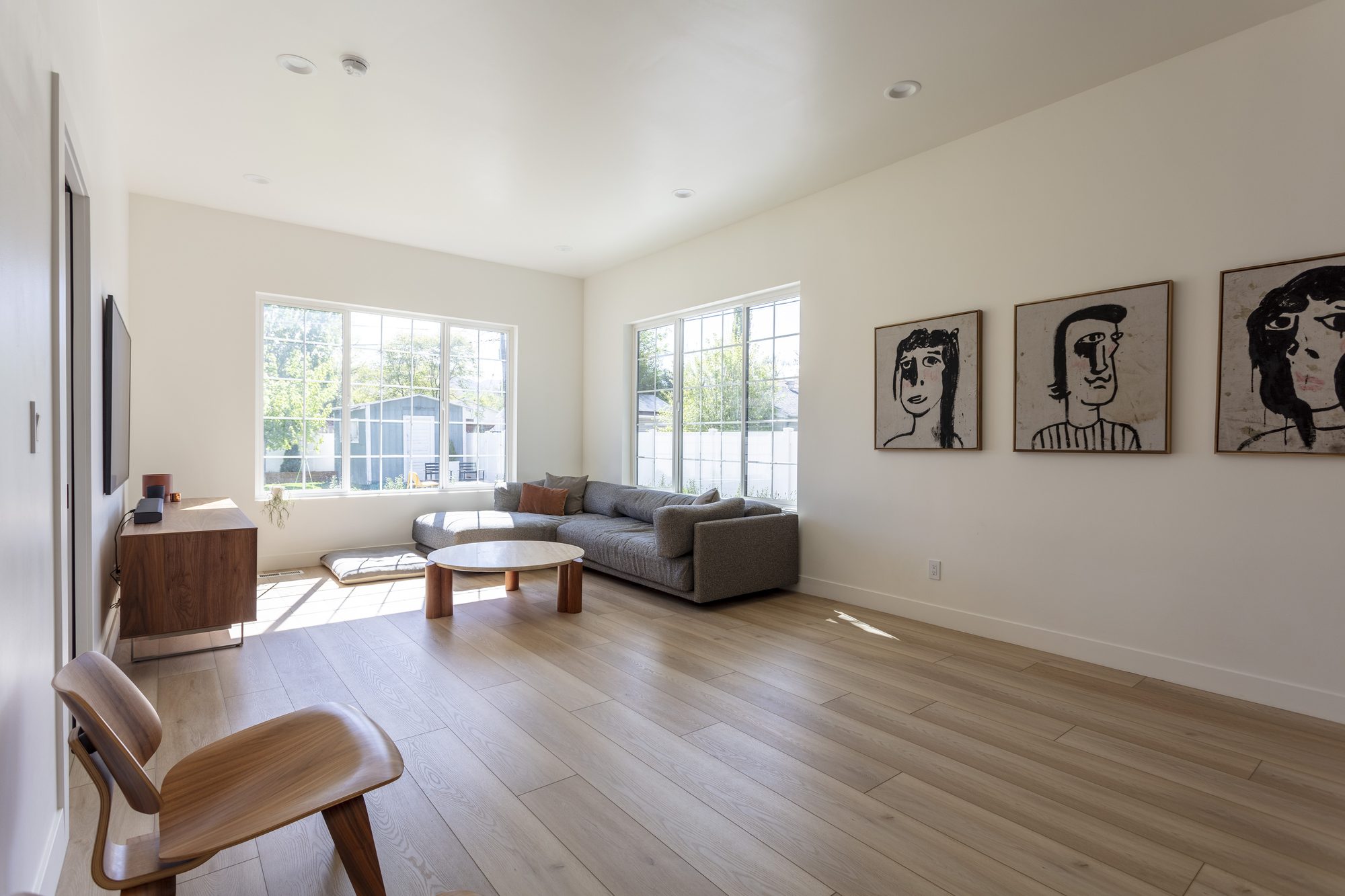Open living room after a whole-home remodel, with white oak floors and wide windows