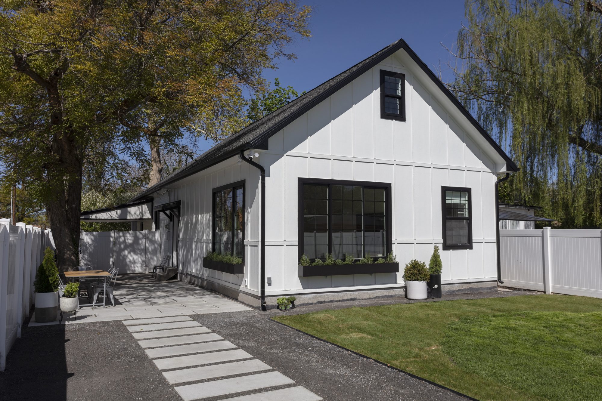 Whole-home exterior remodel with white board-and-batten siding and black windows