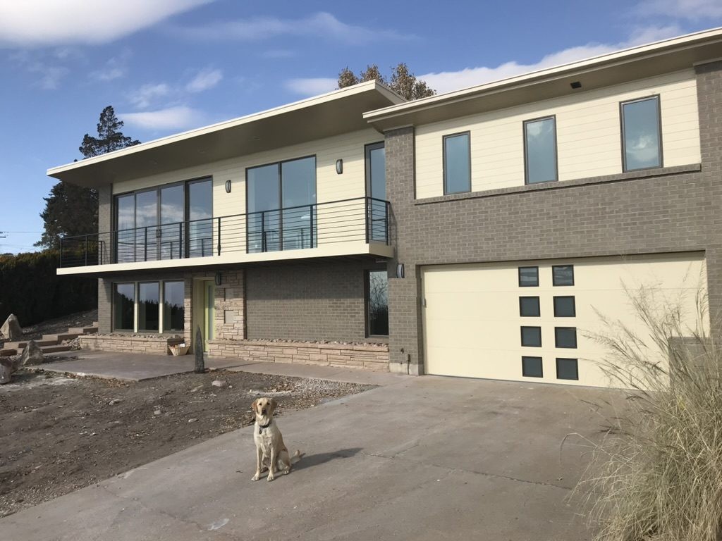 Completed mid-century whole-home remodel with grey brick, cream siding and black railings