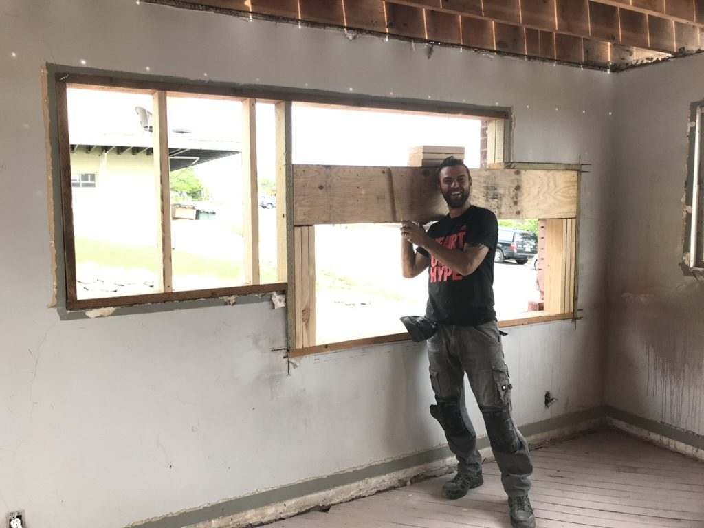 Levi Darger fitting beam into a new window opening during a remodel