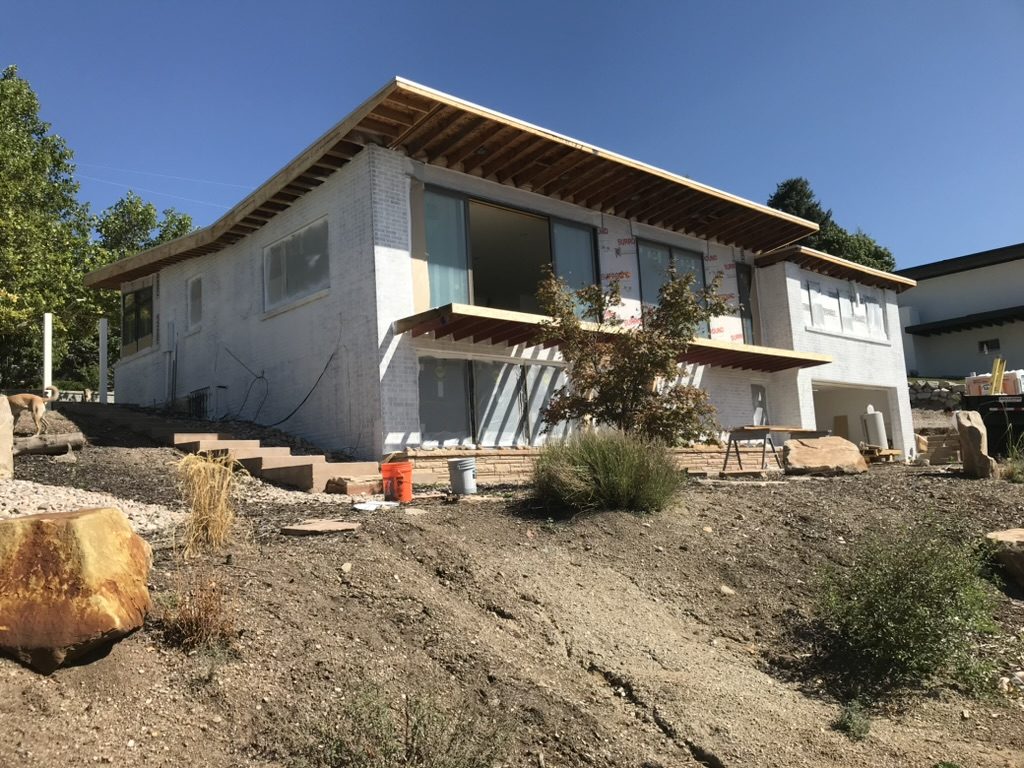 Whole-home remodel in progress, with new roof framing over painted brick