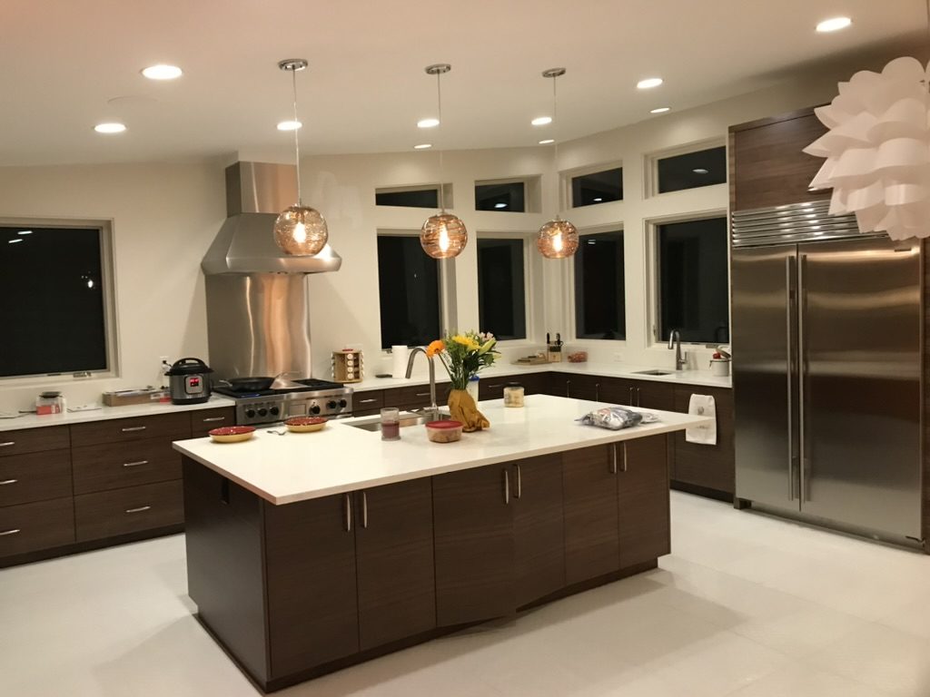 Kitchen renovation in The Avenues, Salt Lake City, Utah with dark walnut cabinets, a large quartz island and glass pendant lighting
