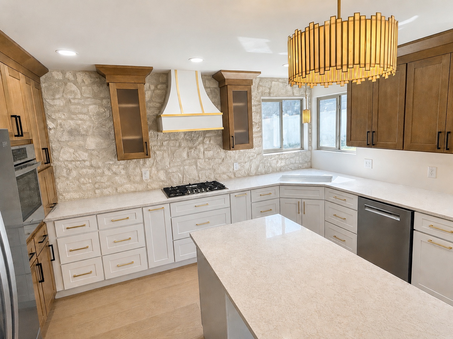 Kitchen remodel in Herriman, Utah with stained oak and gray shaker cabinets, stone backsplash and a custom white and gold range hood over a quartz island