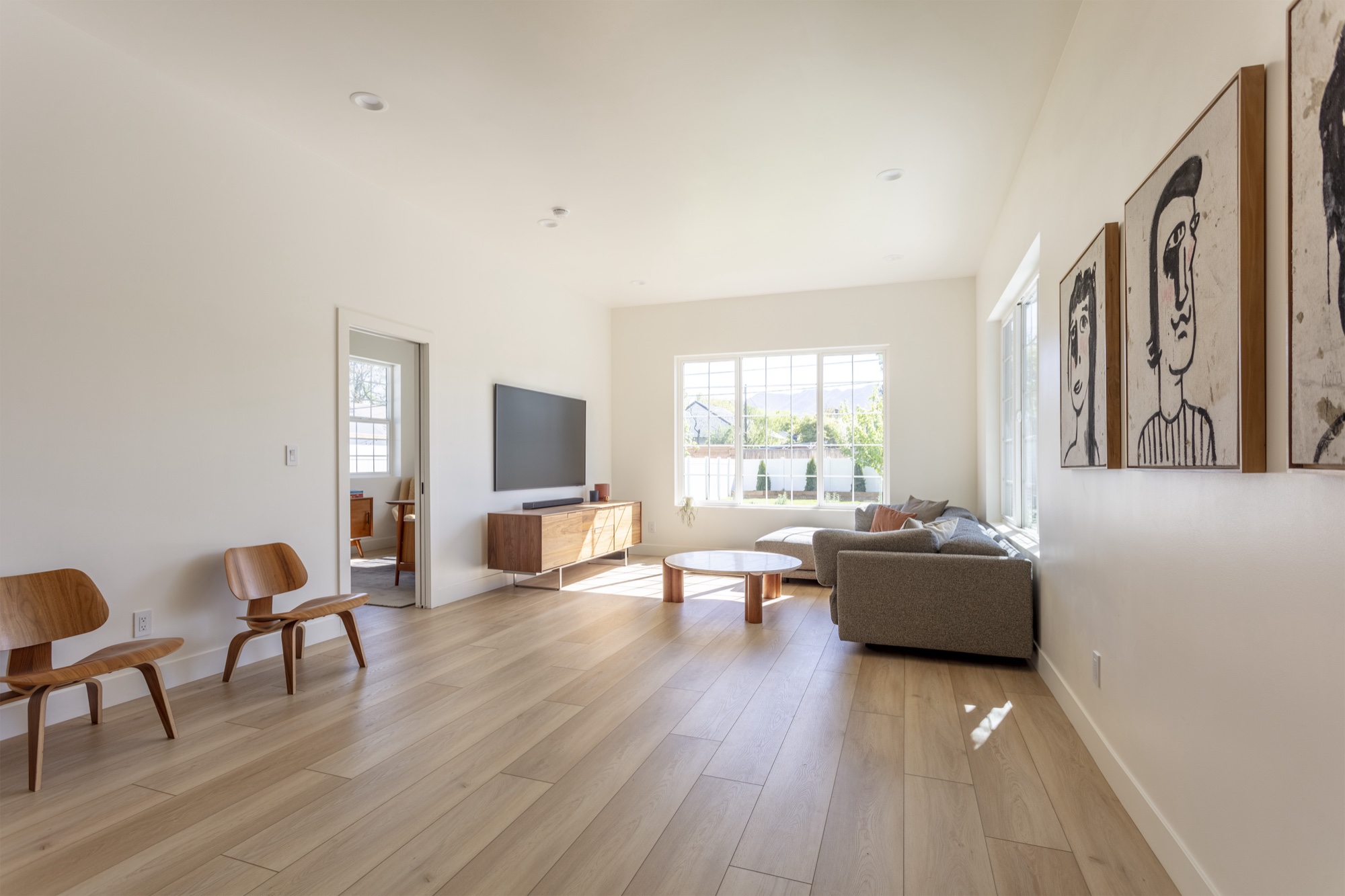 Whole-home remodel in Salt Lake City, Utah: living room with a wall-mounted television over a low credenza and mountain views beyond