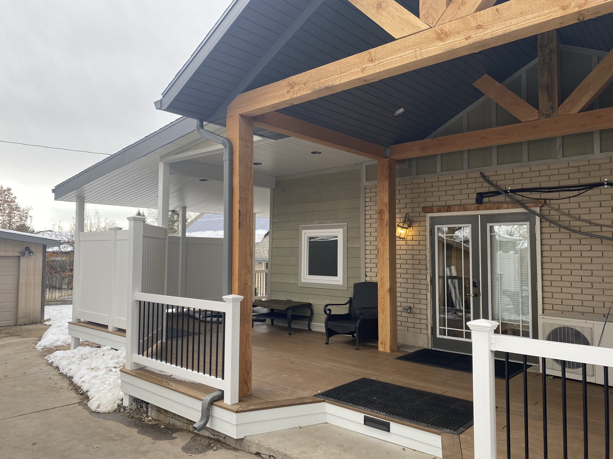 Timber-frame covered porch addition in Cottonwood Heights, Utah, under a cedar king-post gable